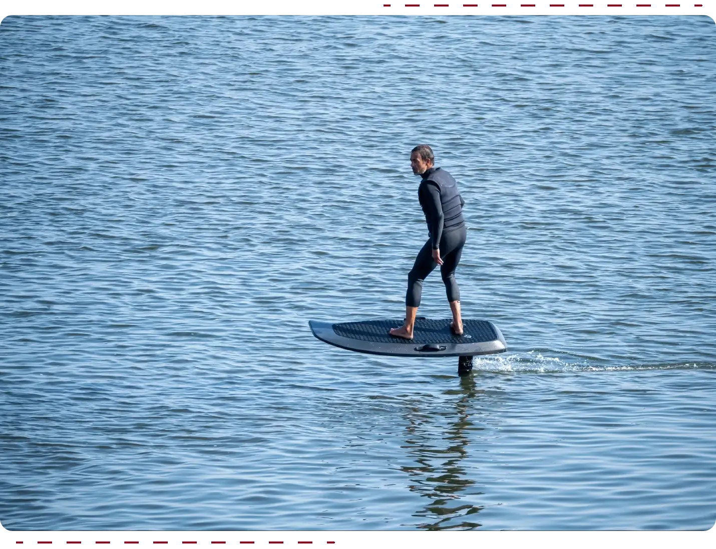 Person riding electric hydrofoil on calm water